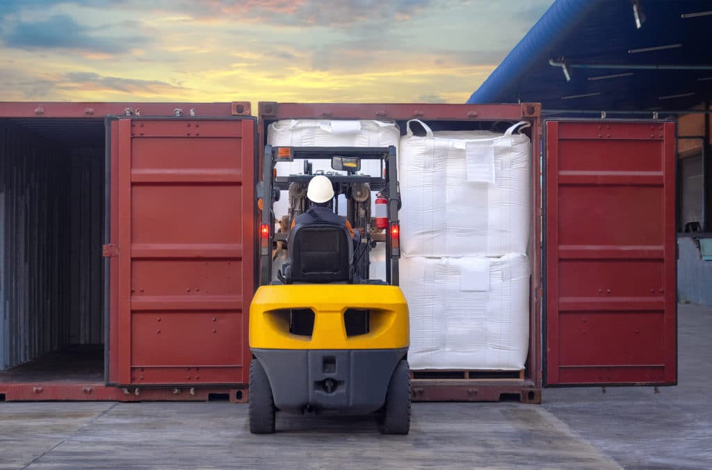 Man placing product and pallets in export container