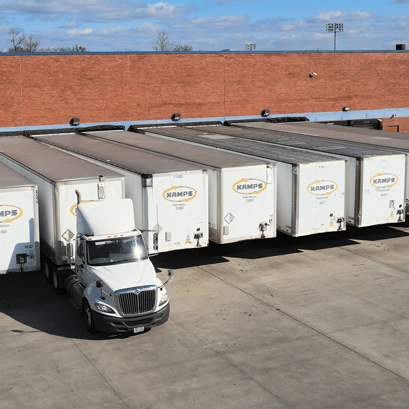 White pallet recycling truck and trailers parked at loading dock