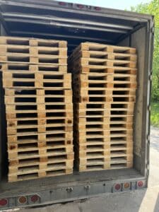 A stack of glass and can pallets inside truck