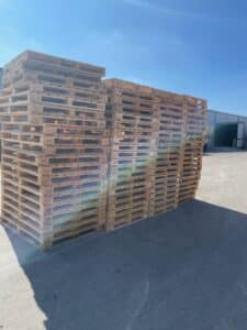Stack of Wooden Glass and Can Pallets outside
