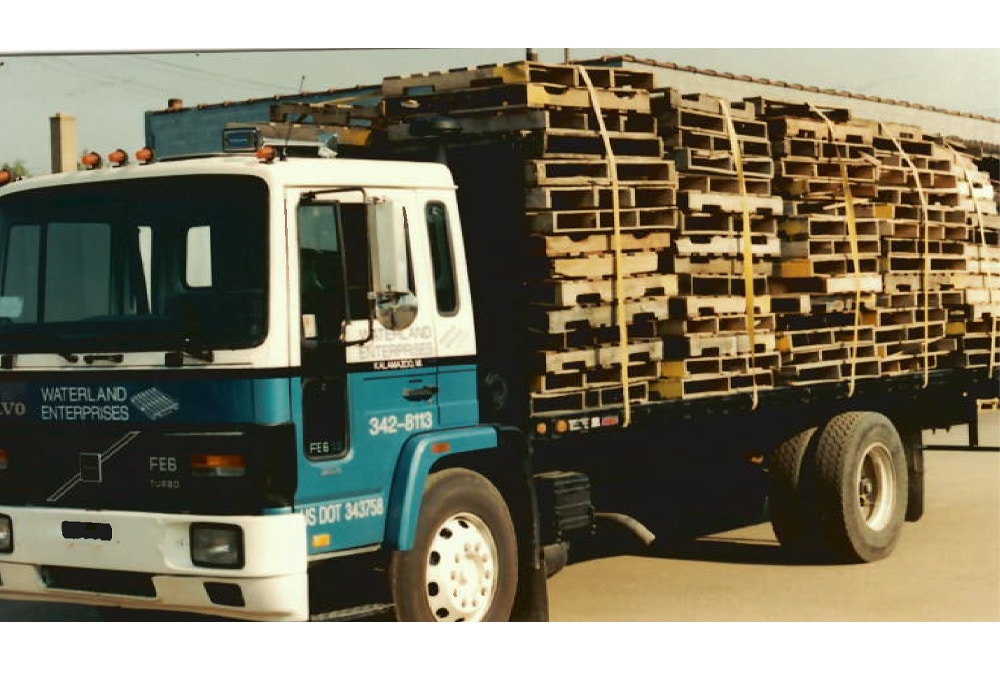 1990s Waterland Enterprises flatbed carrying wood pallets.