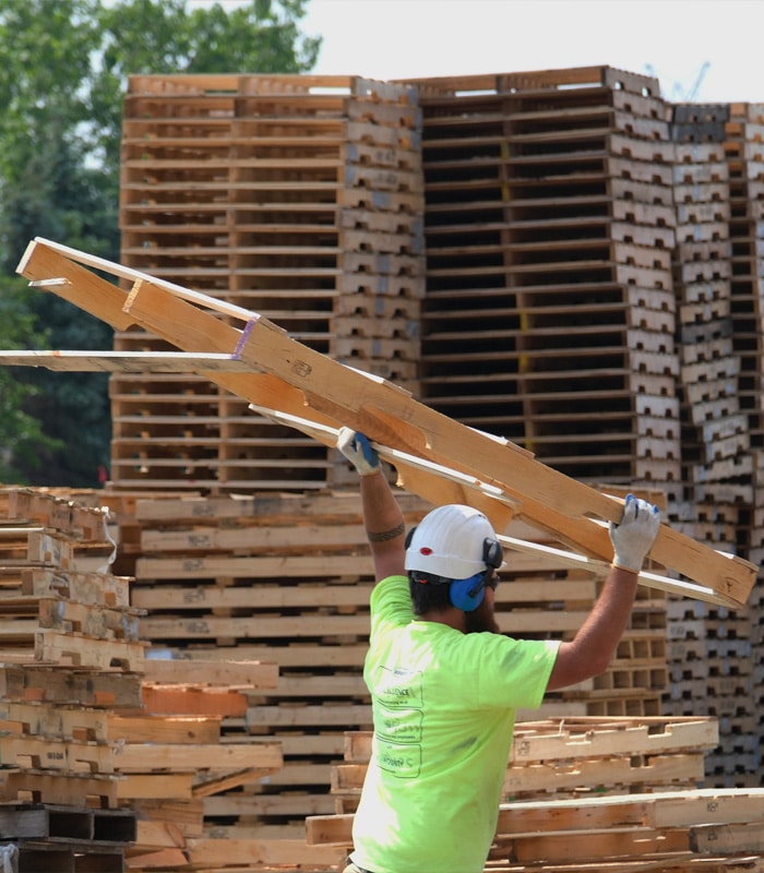Kamps employee moving a wooden pallet in need of repair