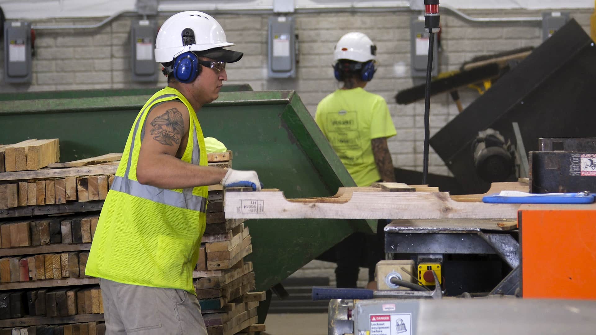 Kamps Pallets employee in high-vis vest repairing pallet